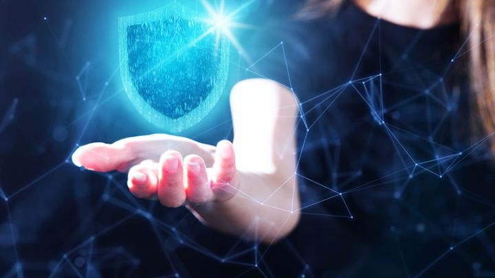 Insurtech concept of a woman with an outstretched hand and a digital shield overing above it. 