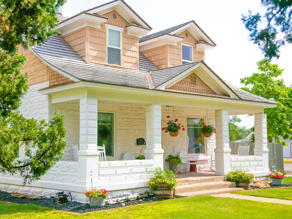 A white and tan American Craftsman style house on a sunny day.